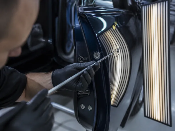 Lectura de reflejos sobre la pintura de un coche durante una reparación PDR